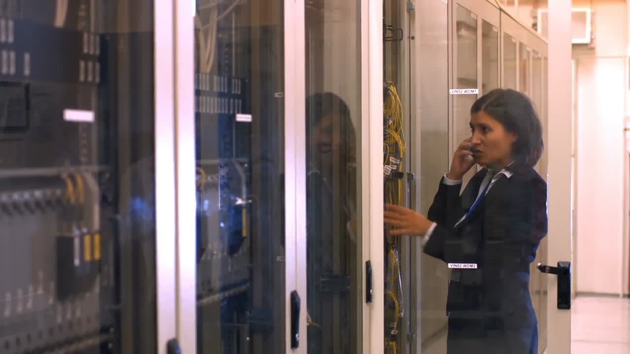 기술자가 서버  ⁇ 에서 휴대 전화로 이야기하고 있습니다.