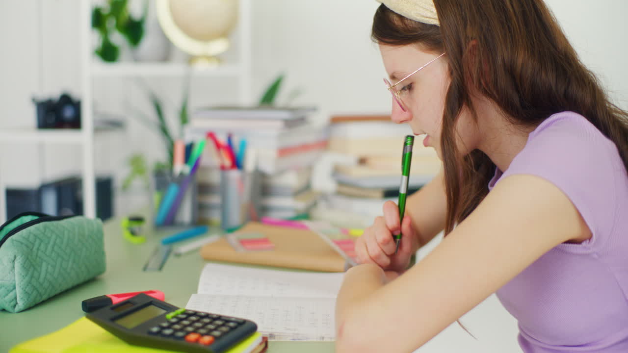 joven estudiante escribe en un cuaderno, hace su tarea y estudia para la escuela