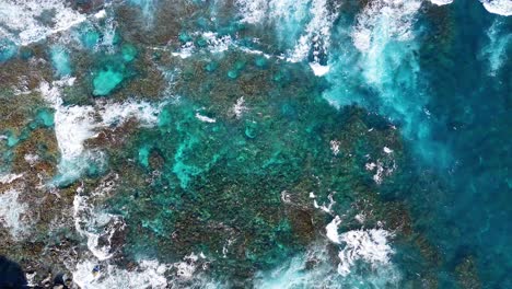 aerial view of waves hitting rocky shoreline