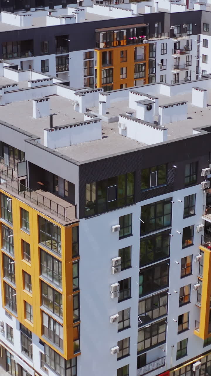 Modern residential building. Beautiful design of a new city complex. High-rise apartment buildings with windows and balconies. Aerial view. Vertical video