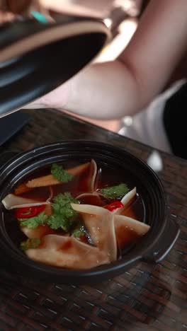 woman eating dumplings soup