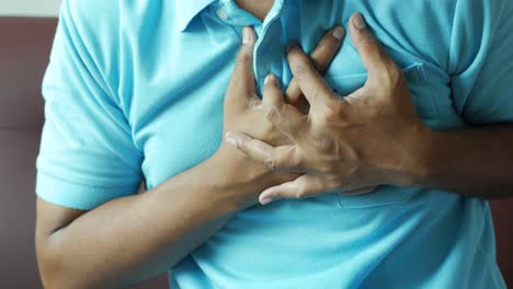 Young-man-suffering-pain-in-heart-and-holding-chest-with-hand