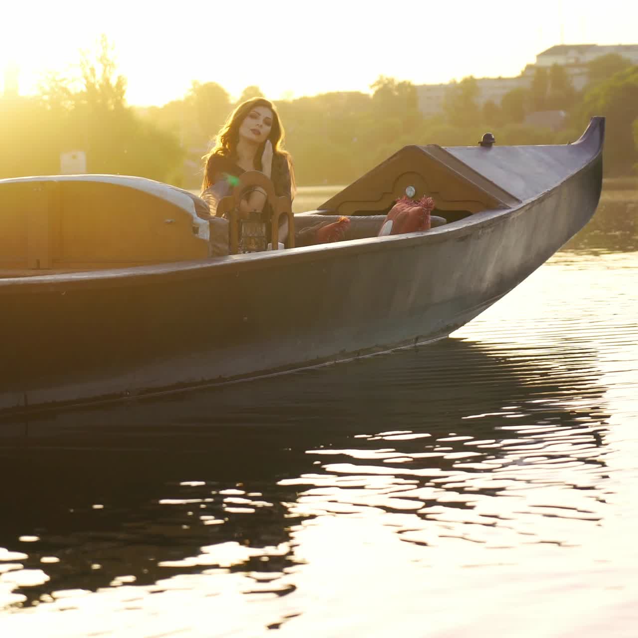 beautiful woman in a dress is sitting and posing on a gondola in Venice