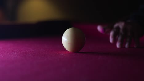 man ready himself and hits the cue ball on the pool table