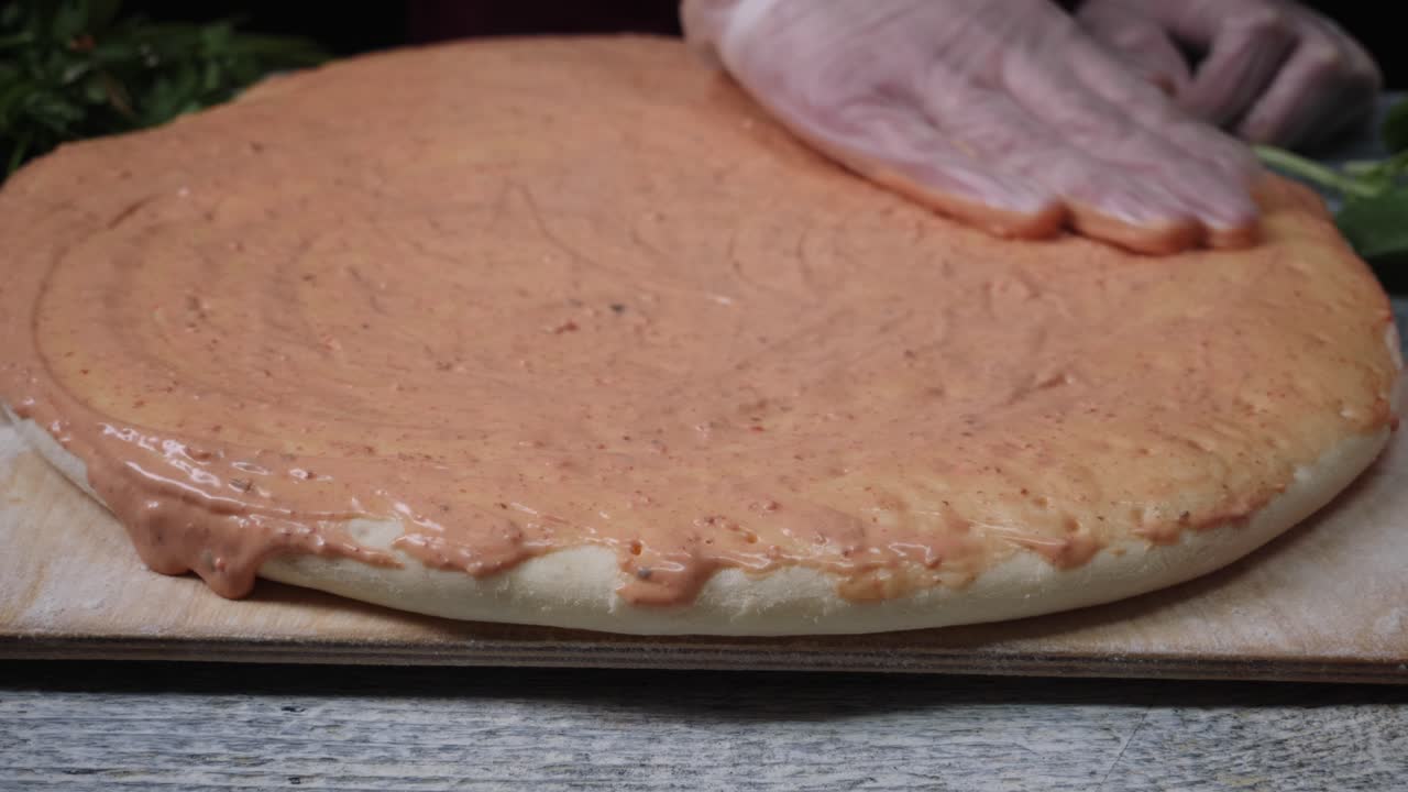 preparando una pizza con salsa