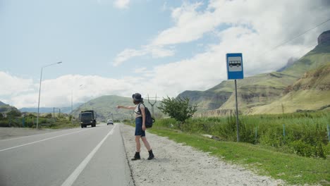 woman waiting for a bus at a mountain bus stop