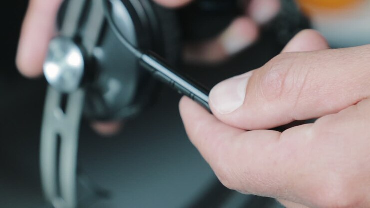 Male hand showing remote control features on a set of cable headphones