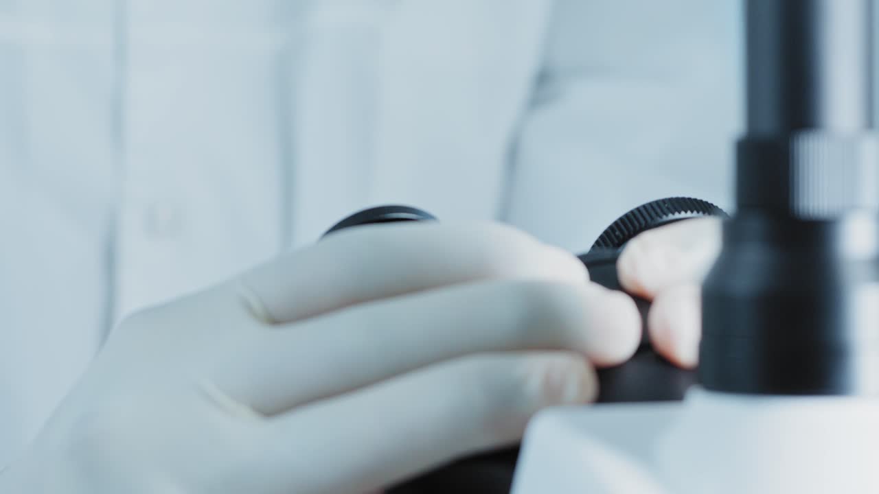 실험실 에서 현미경 을 사용하는 과학자