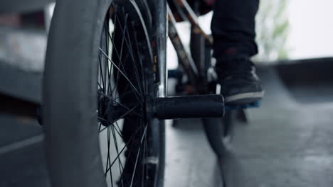 man legs bmx bike at skate park. close up bicycle wheels at skatepark.