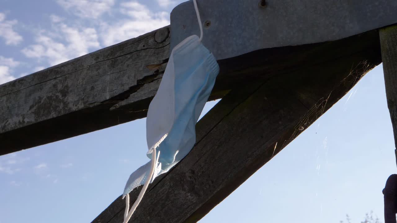 Face mask left on wooden fence close up shot