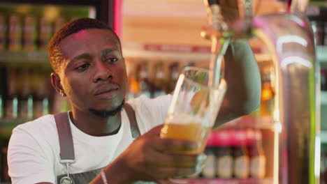 bartender pouring beer from a tap