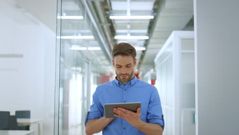 hombre de negocios trabajando con una tableta en la oficina. hombre guapo usando un dispositivo digital en el interior.