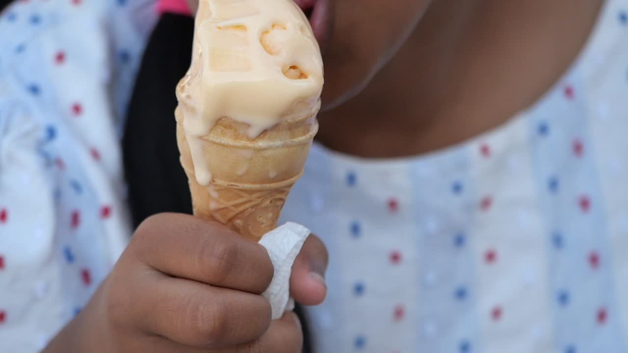 A person eats a melting ice cream cone