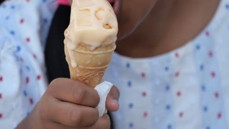 a person eats a melting ice cream cone