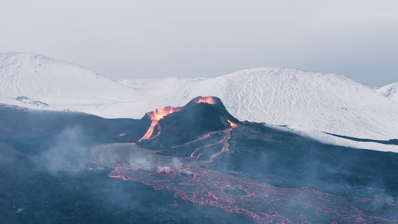 Fagradalsfjall eruption in Iceland with snow covered mountains in background