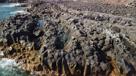 sea waves crashing into rocky coastline of tenerife island, aerial view