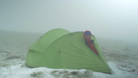 rocky alpine peaks, landscape of a slovakian tatra mountains, male hiker looking out of a pitched tent right after the flock of birds fly over, fresh snow on the ground