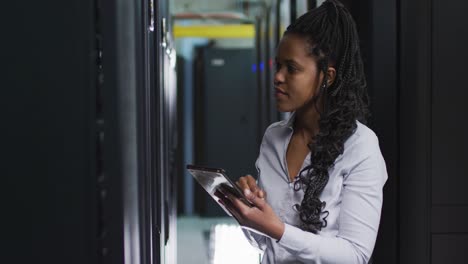 African-american-female-computer-technician-using-tablet-working-in-business-server-room