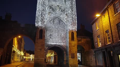 city wall of medieval city lit up with fairy lights at night time in historic city of york