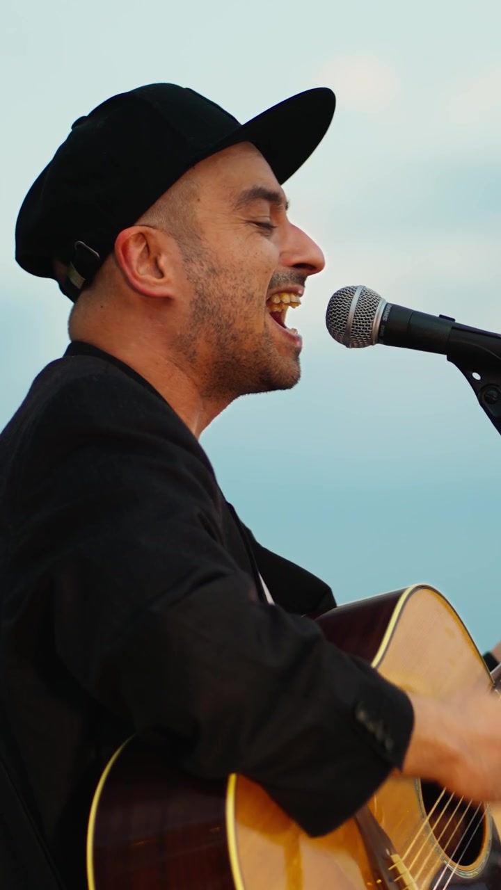 Man Singing and Playing Acoustic Guitar Outdoors