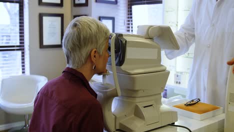 optometrist examining patient eyes with autorefractors 4k