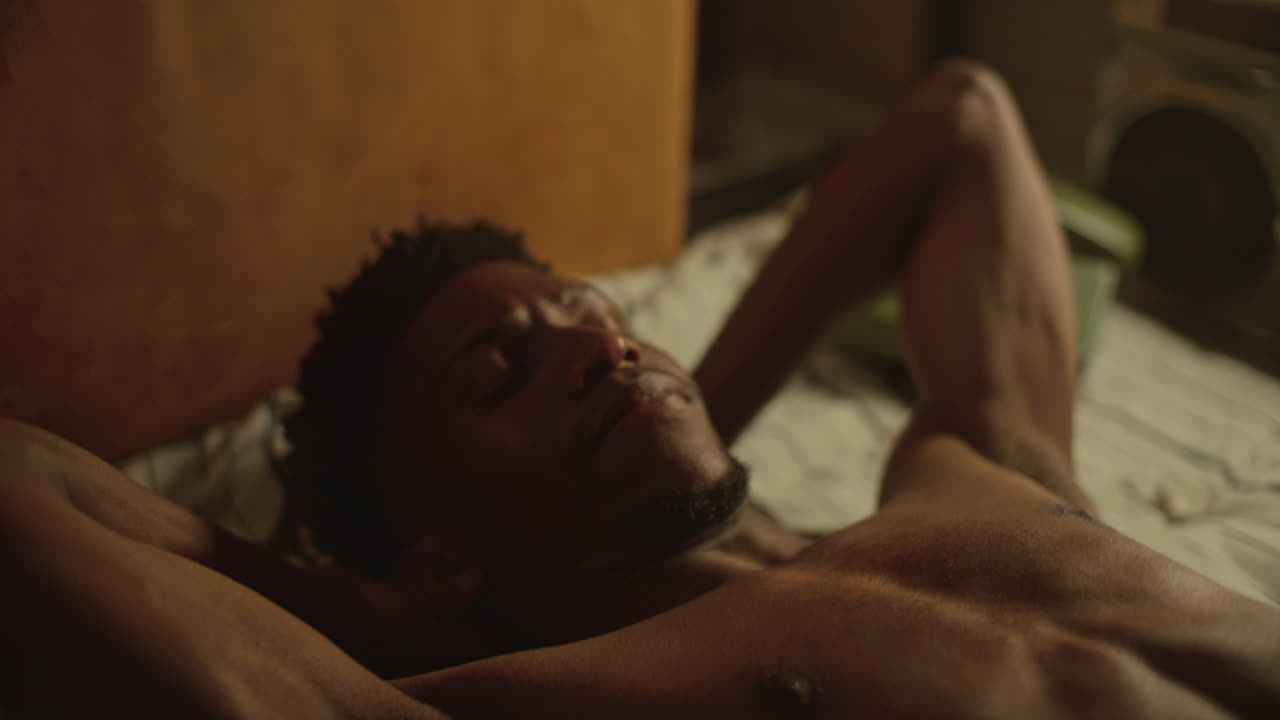 Young African American Man Doing Ab Crunches on Bed at Home