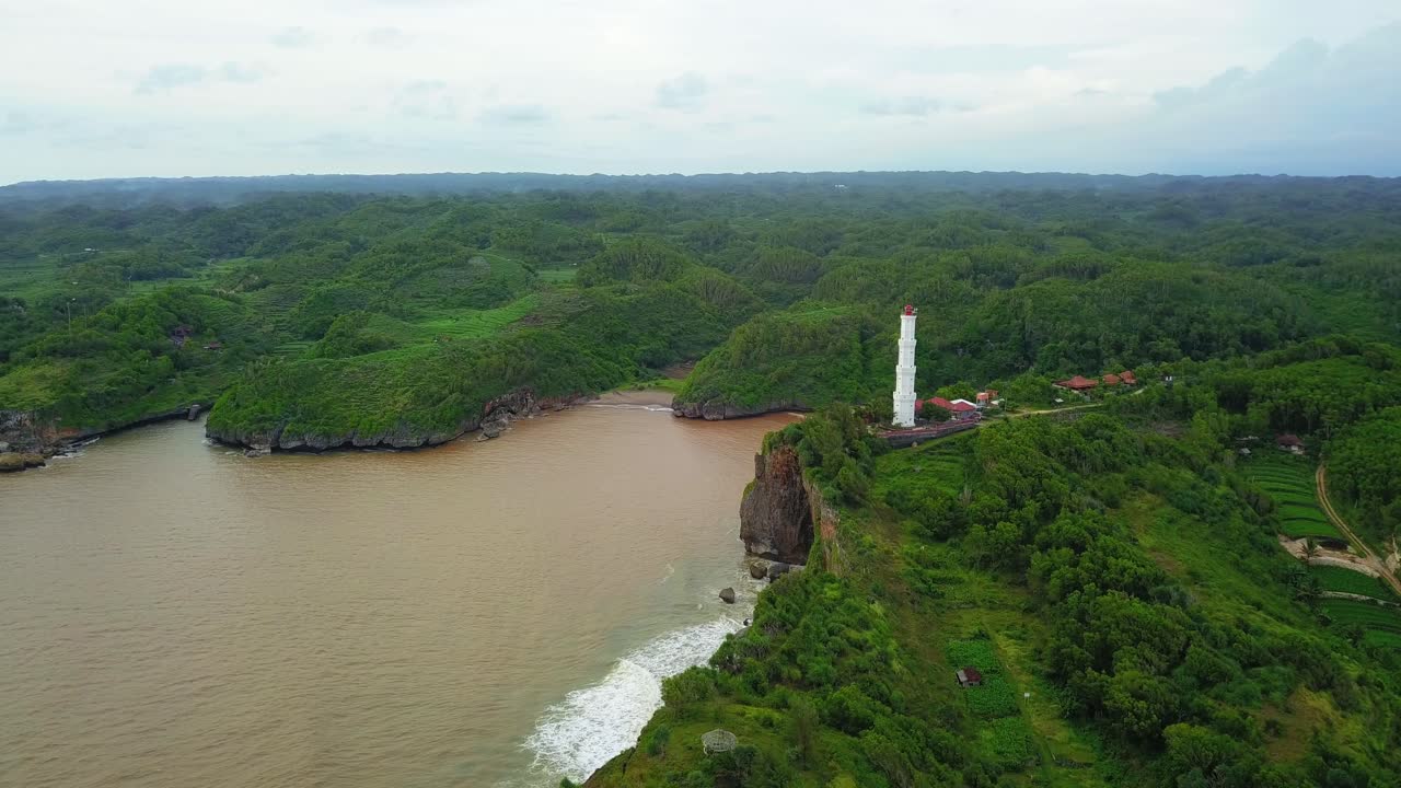 las olas del océano chocan contra las peligrosas rocas de los acantilados debajo de los barcos de advertencia del faro alto