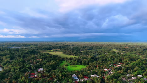 Vast green scenery of beautiful Sri Lanka, South Asia. Cottages hide in the lush greenery of tropical forests. Dark cloudscape covering the sky.