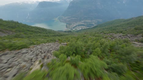 Vuelo-Aéreo-Fpv-Cuesta-Abajo-Montañas-Verdes-Hacia-La-Famosa-Ciudad-Turística-Odda-Y-Fiordo-En-El-Valle