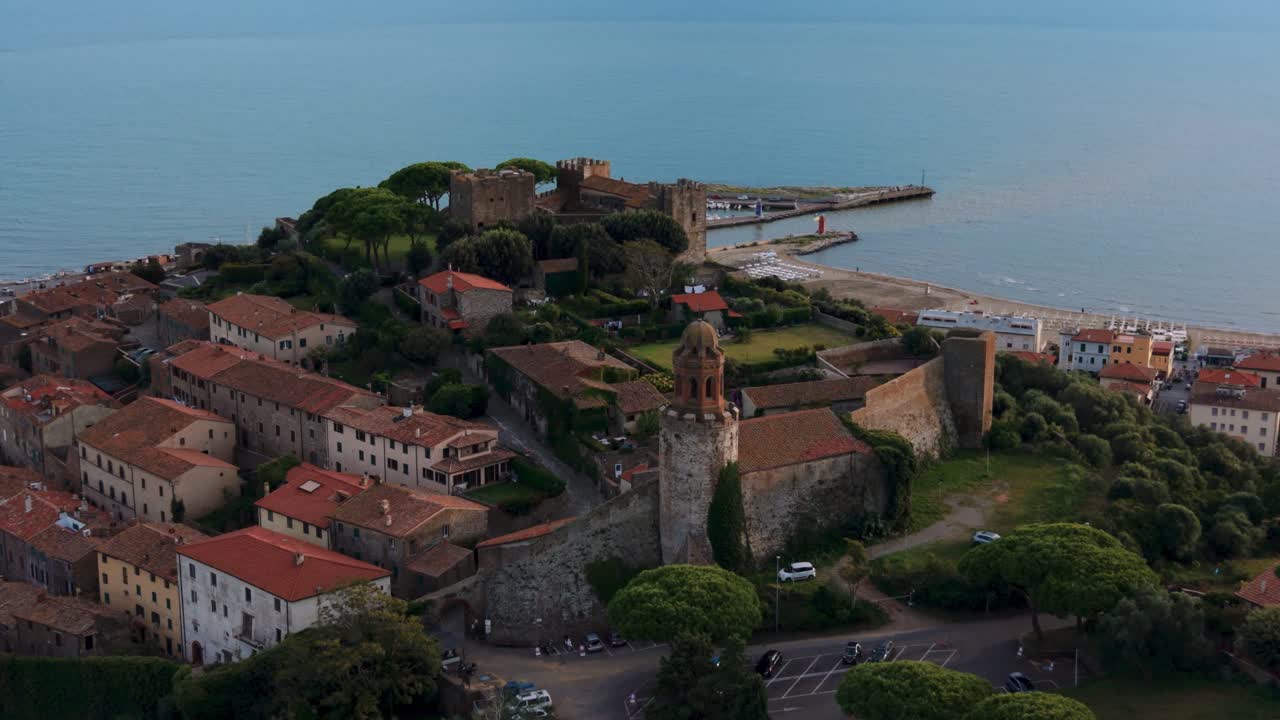 Drone rotation around Castiglione della Pescaia castle with sea horizon and historic village rooftops