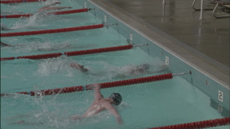 Male-swimmers-reach-the-finish-line-one-swimmer-raises-his-arms