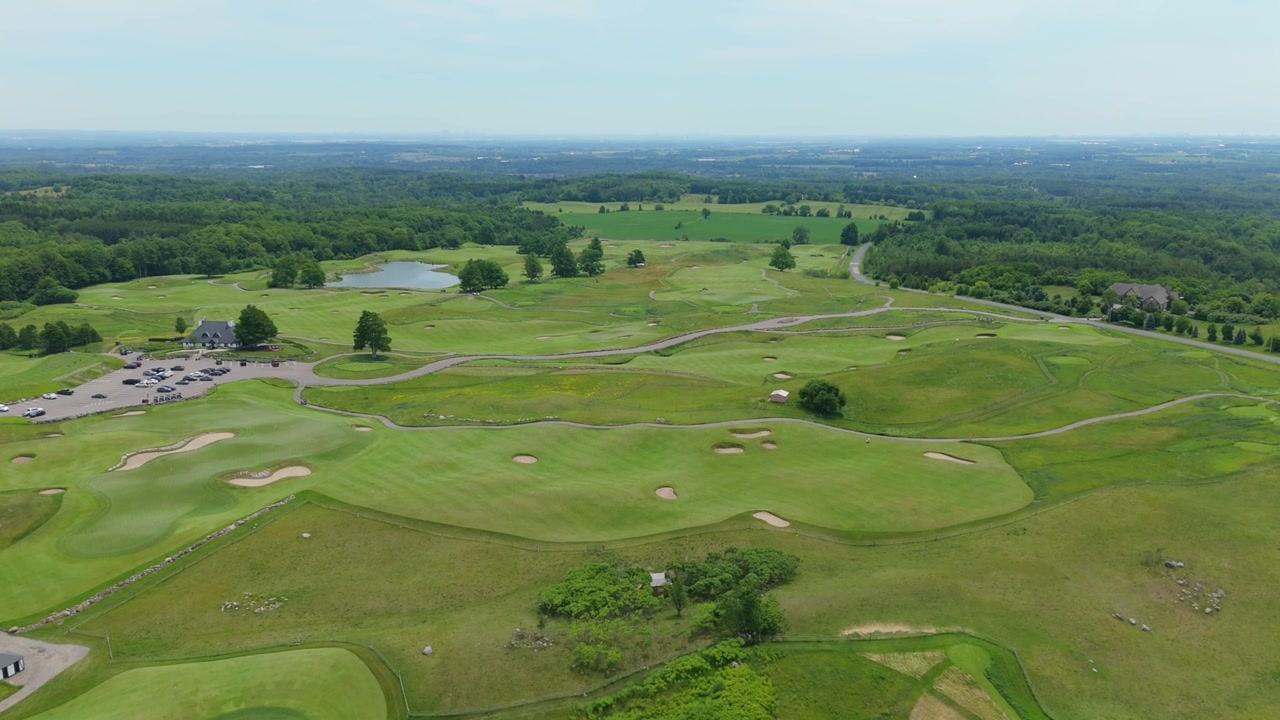 The Paintbrush golf course fairways and clubhouse parking lot stretch across rolling green hills.