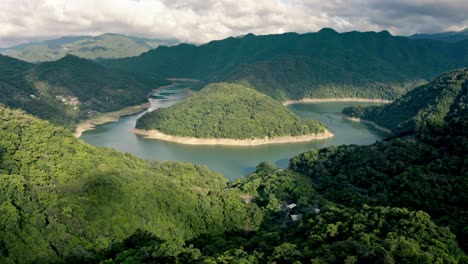 Drohne-Enthüllt-Aufnahme-Des-Grünen-Fei-ts&#39;ui-reservoirs-Mit-Blauem-Fluss-Und-Wolkenlandschaft