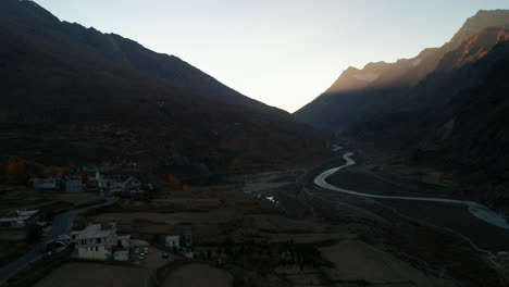 fría mañana de otoño aérea desde un pequeño y tranquilo pueblo de montaña con vistas a un glaciar