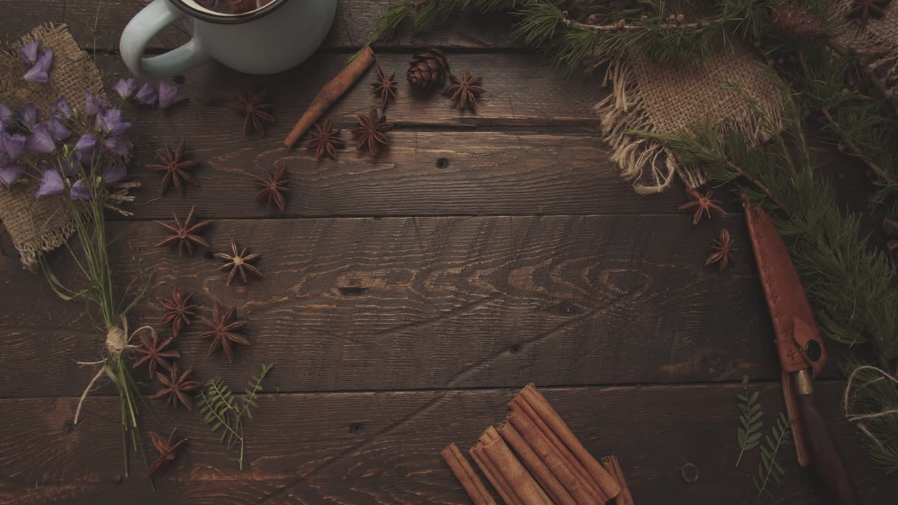 Hands Arranging House with Dried Spices on Wooden Table with Pine Branches