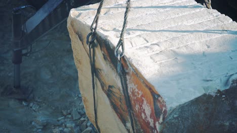 lifting and moving a stone with a crane. sandstone quarry. close-up