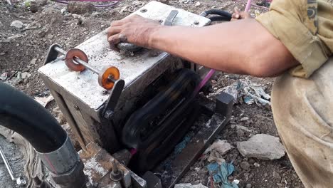 a man pushes fiber optic cable by cable-pusher machine, fit for laying underground cables in long conducts and in harsh conditions, cable feeder sender pusher machine for underground cable