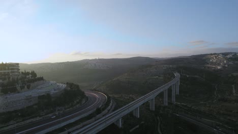 aerial shot of sunset over a forest and railway bridge