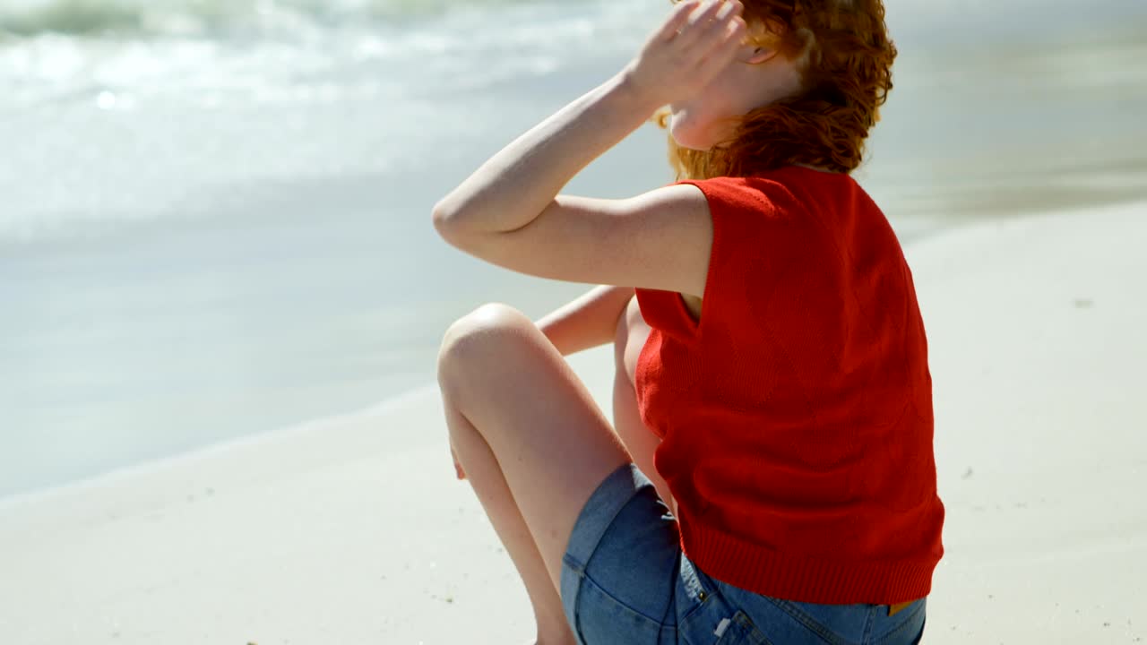 모래 위에 앉아서 바다를 바라보는 여자 4k