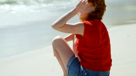 mujer sentada en la arena y mirando al mar 4k