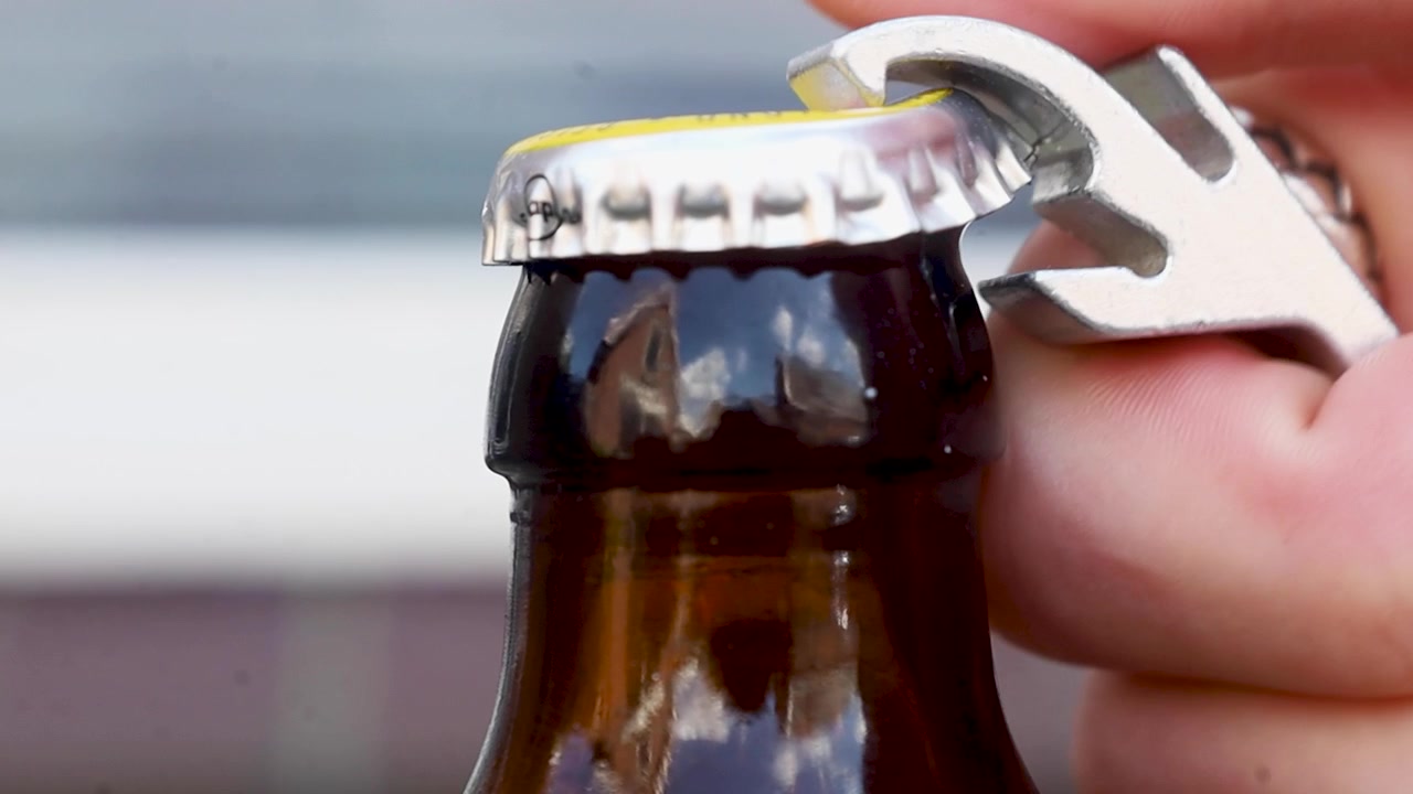 Video che cerca di aprire una bottiglia di birra con un apribottiglie.