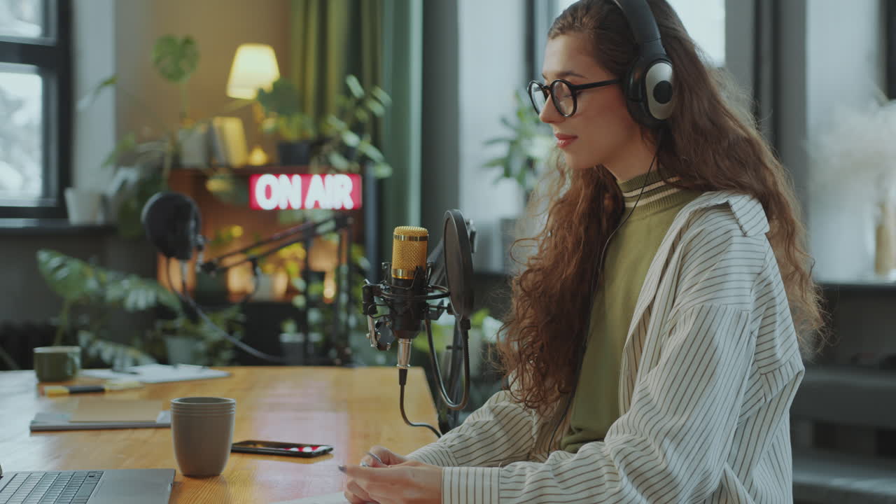 retrato de una podcaster feliz en un escritorio en un estudio de grabación