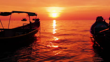 Aerial-shot-of-Koh-Tao-island,-Super-sunset-at-Sairee-Beach-with-many-boats-floating-Thailand