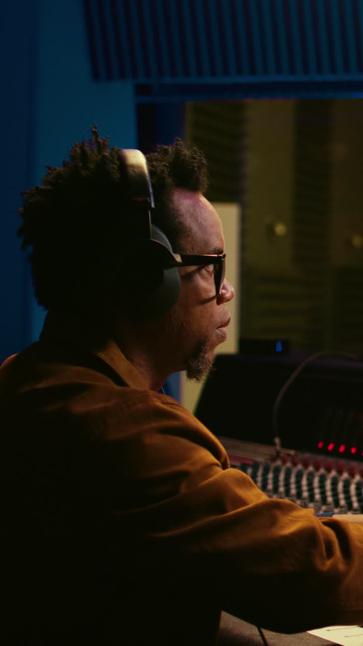 Male Audio Engineer Working at Sound Mixing Console in Studio