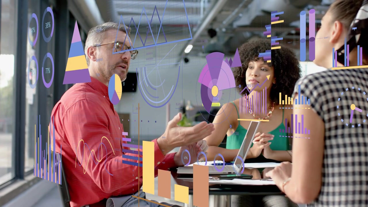 Team of three reviewing business data, man gesturing, initiating animated charts over laptop