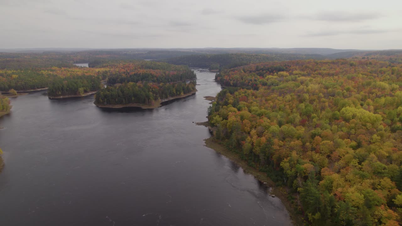 An autumn view of the Gatineau River with the islands covered with trees in autumn colours