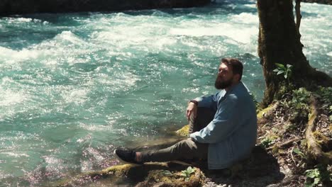 hombre relajándose junto a un río