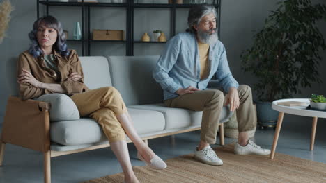 una pareja discutiendo en un sofá.