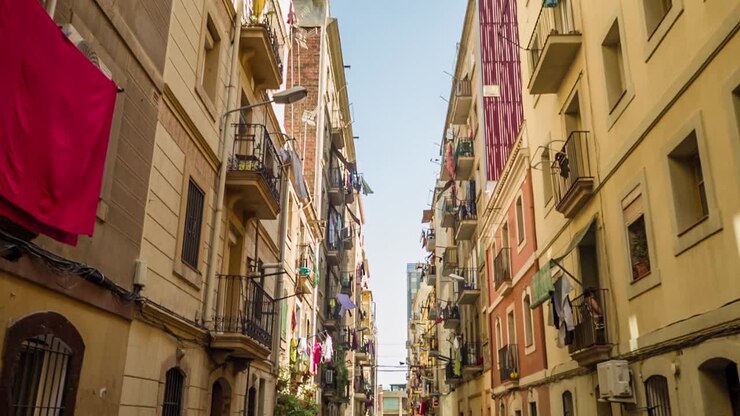calle estrecha en barcelona con balcones y lavandería