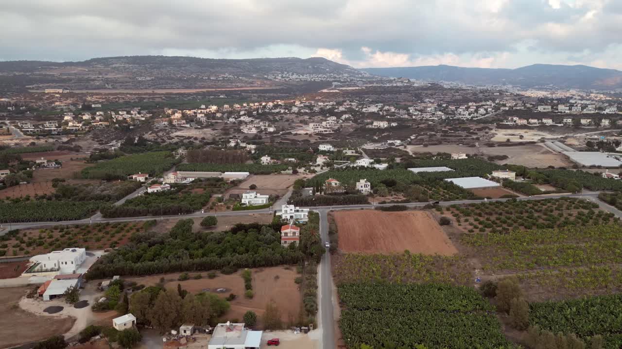 Scenic aerial drone capture of a housing estate community surrounded by industrial buildings and farmlands, blending residential, industrial, and agricultural landscapes.